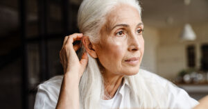 Senior woman experiencing early signs of hearing loss
